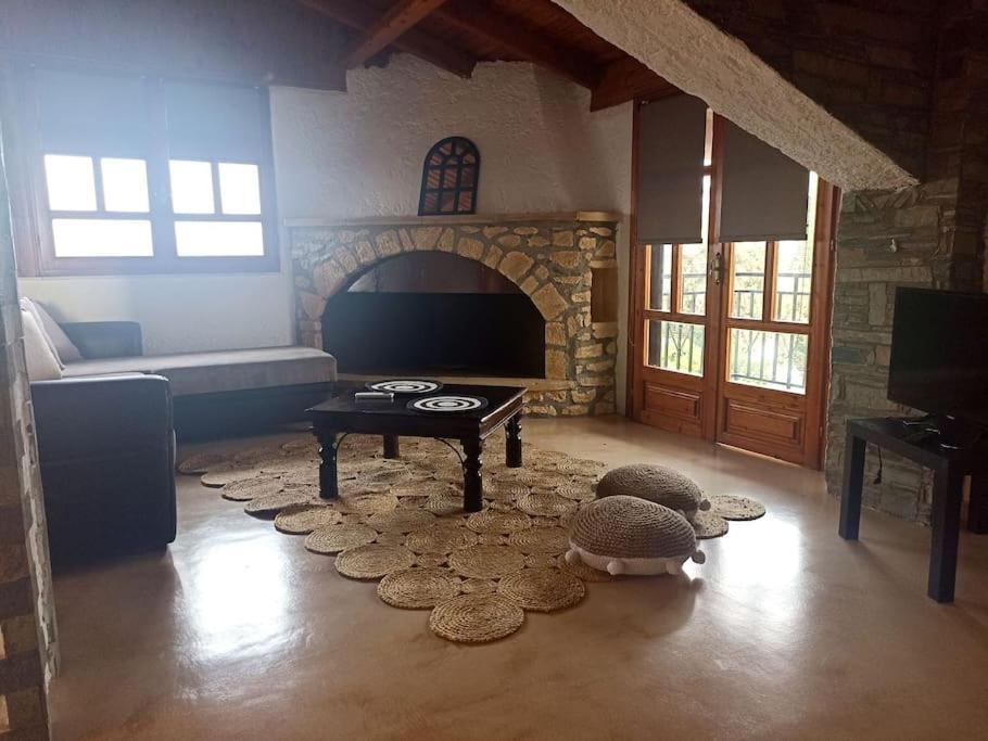 sala de estar con sofá y chimenea de piedra en Cozy house en Tagarades