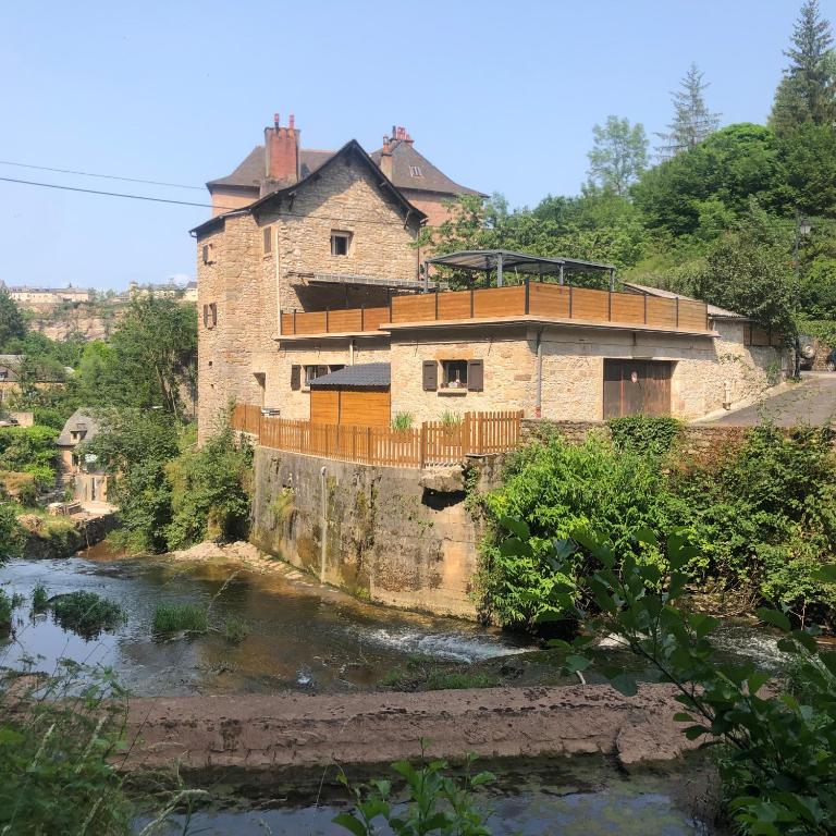 une vieille maison au bord d'une rivière dans l'établissement Les rives du Dourdou, à Bozouls
