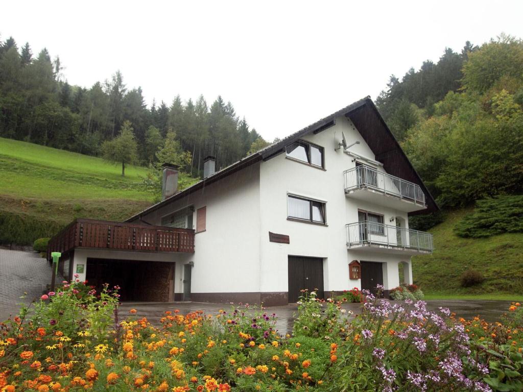 ein weißes Gebäude mit einem Balkon und Blumen in der Unterkunft Modern Apartment in Bad Peterstal Griesbach with Vineyards in Bad Peterstal