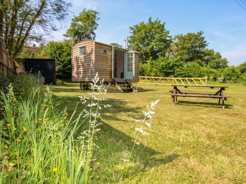 a tiny house in a yard with a bench at Acres Meadow in Dorchester