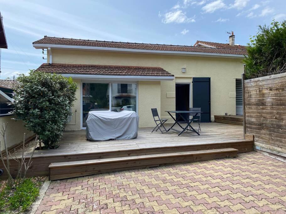 une terrasse avec une table et des chaises dans une maison dans l'établissement Maison proximité centre-ville, à Arcachon