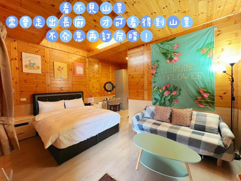 a bedroom with a bed and a couch and a table at Lala Mountain Homestay‧Cile Farm in Hualing