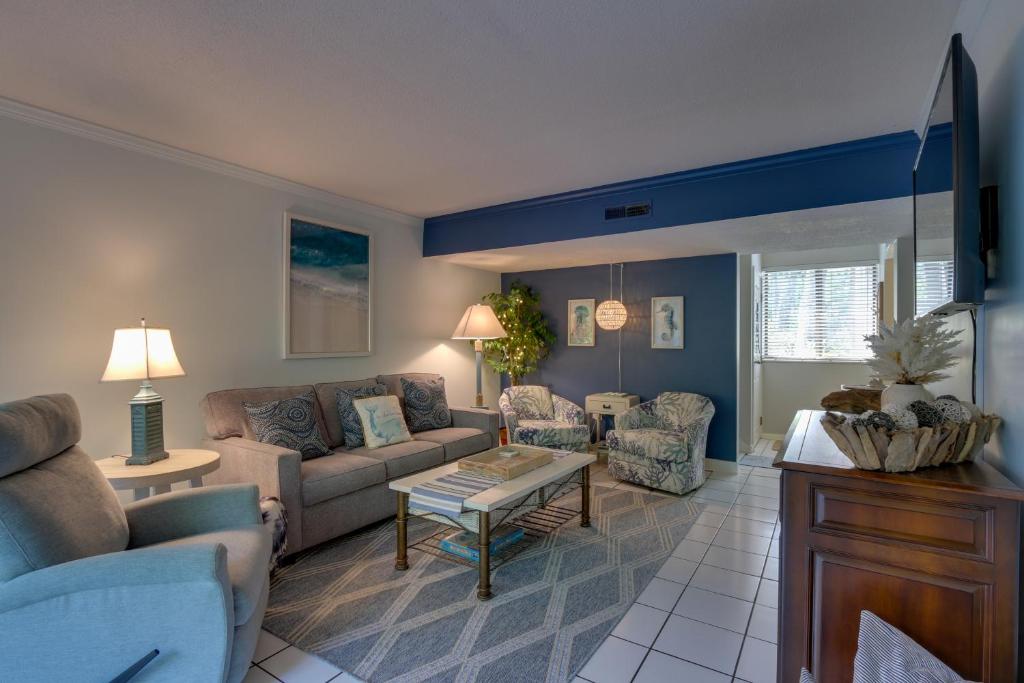 ein Wohnzimmer mit einem Sofa und einem Tisch in der Unterkunft Serene Hilton Head Island Condo with Community Pool! in Hilton Head Island