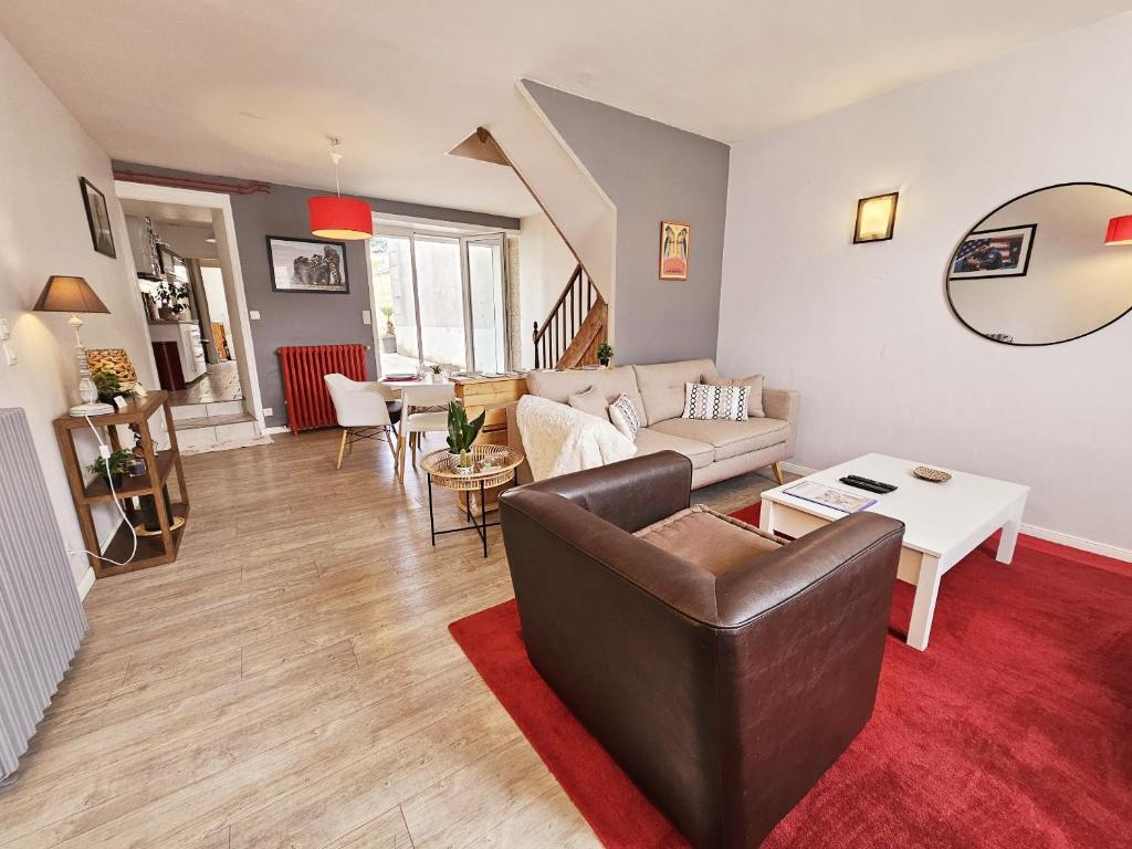 uma sala de estar com um sofá e uma mesa em Maison de ville confortable avec cour interieure em Angoulême