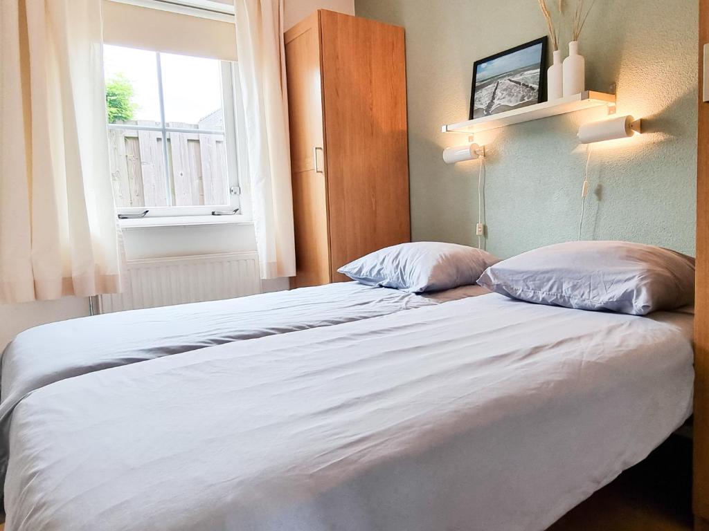 2 camas en una habitación con ventana en Vakantiewoning Domburg DO34, en Domburg