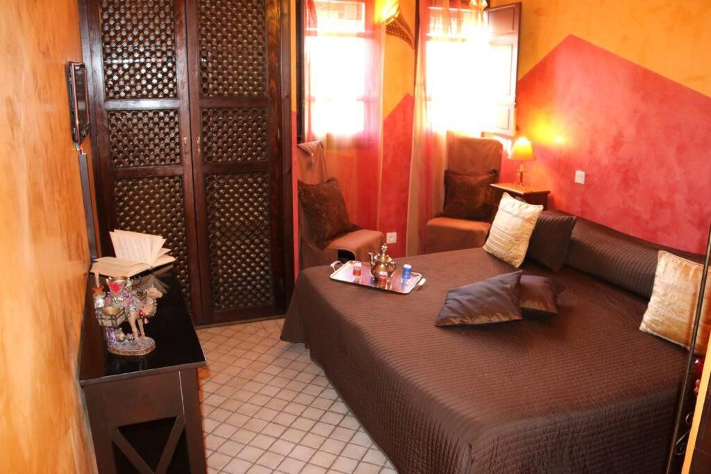 ein Schlafzimmer mit einem Bett, einem Sofa und einem Stuhl in der Unterkunft Chambre Merzouga, Riad 8 au village naturiste Couple only in Cap d'Agde