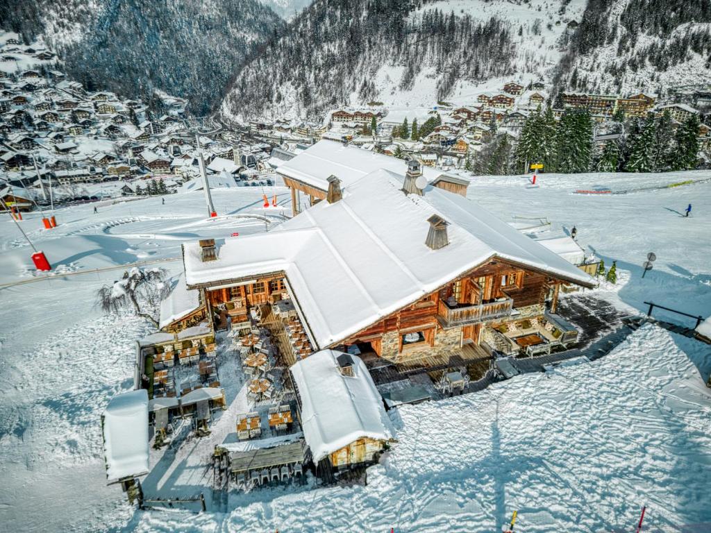 a log cabin in the snow with a mountain at Le Vieux Chalet in La Clusaz