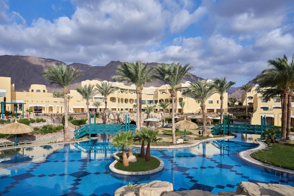 a view of the resort with palm trees and buildings at The Bayview Taba Heights Resort in Taba