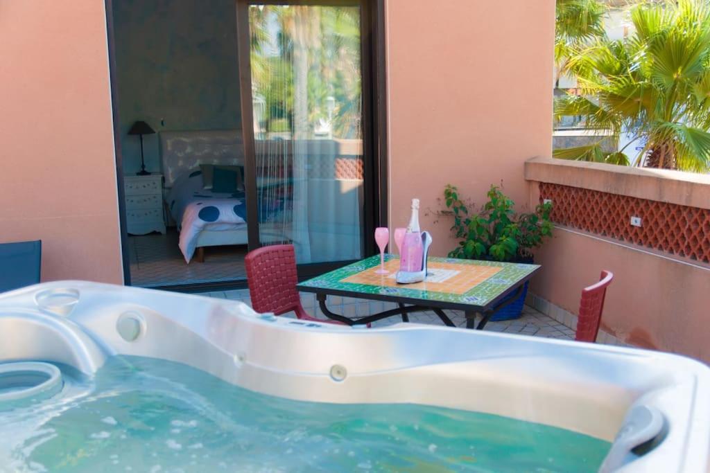 a bath tub sitting next to a table with a tableablish at Suite Essaouira, Riad 8 au village naturiste Couple only in Cap d&#39;Agde