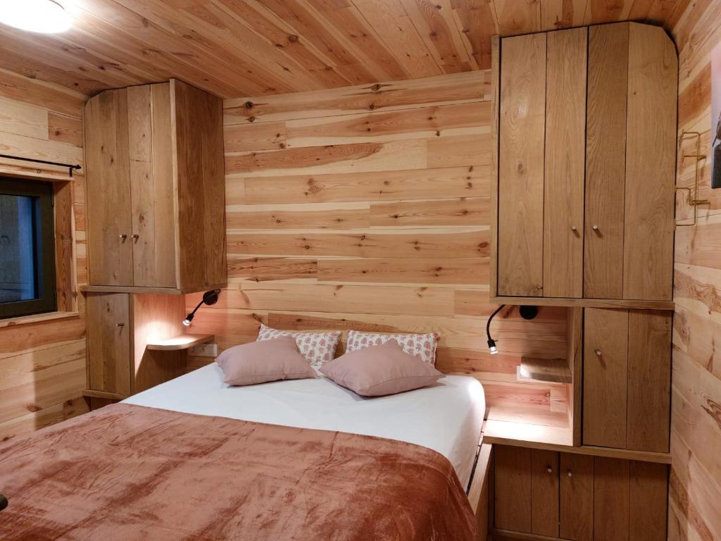 een slaapkamer met een bed in een houten hut bij La Bucolique de Tahier in Ohey