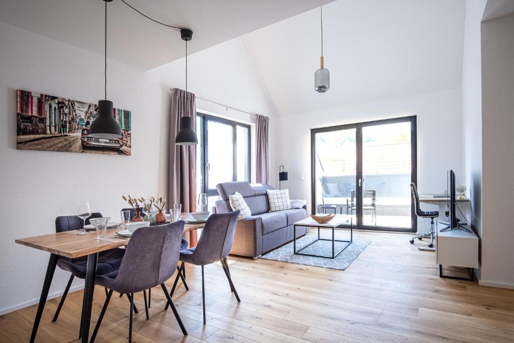 uma sala de estar com uma mesa e um sofá em KEEP Business Suite H66-2 nahe Audi & Schwarz Gruppe mit Balkon, Netflix & Parkplatz em Oedheim