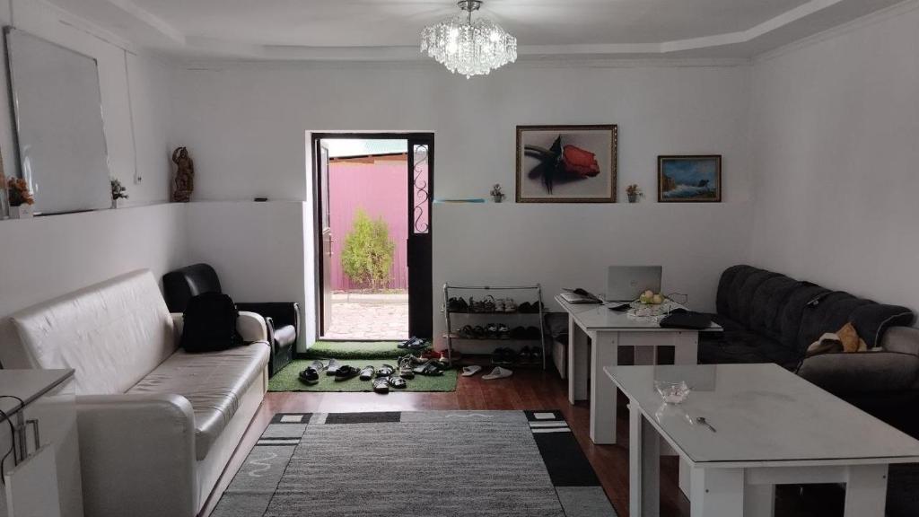 a living room with a couch and a table at Nomadstan CAPSULE Hostel in Karakol