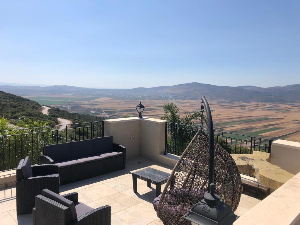 a patio with a couch and a table and a view at צימרימון in Bet Rimmon