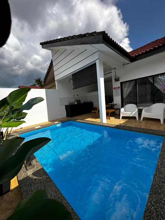 une piscine bleue en face d'une maison dans l'établissement Angsamas Villa Seremban Kids Private Pool & Jacuzzi, à Seremban