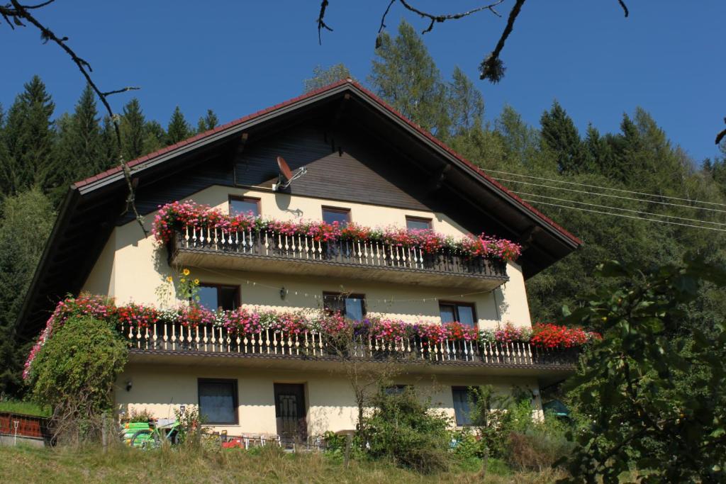 ein Haus mit Blumenkästen an der Seite in der Unterkunft Haus Königshofer in Sankt Kathrein am Hauenstein
