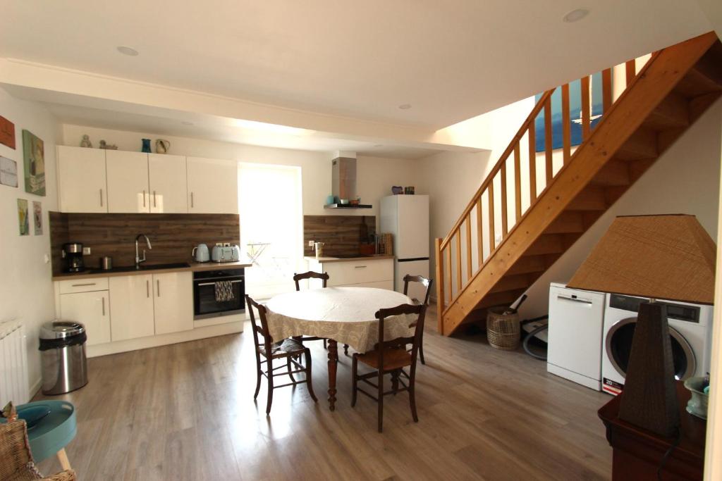 a kitchen with a table and chairs and a staircase at Joli appartement avec balcon au coeur de Forcalquier in Forcalquier