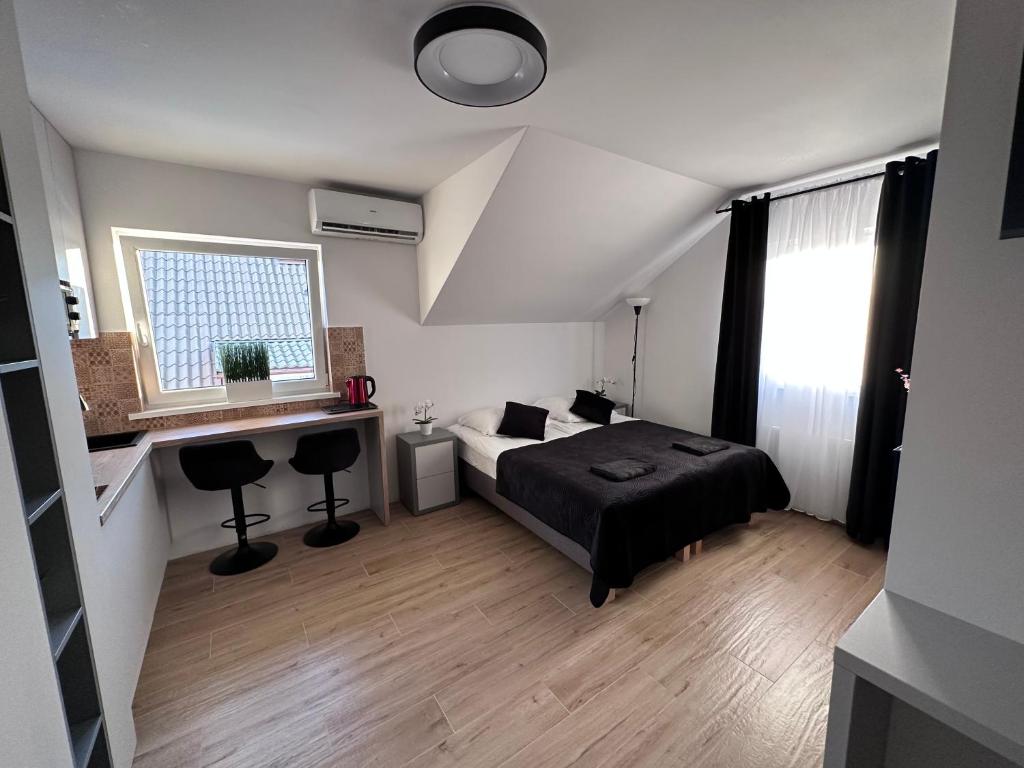 um quarto com uma cama, uma secretária e uma janela em NT Holiday em Dźwirzyno