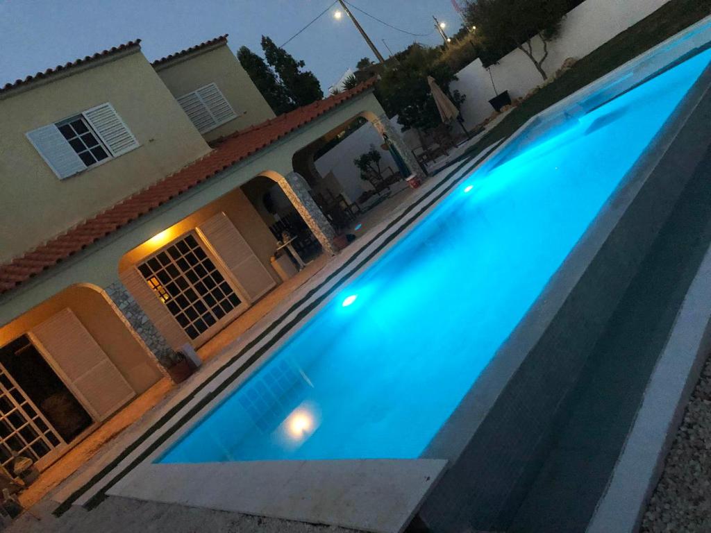 una grande piscina blu di fronte a una casa di Moradia penina v3 a Portimão