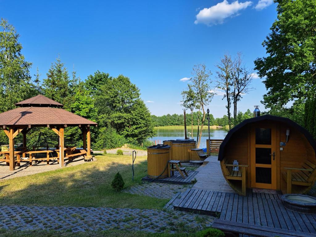 a gazebo and a gazebo with a deck at Domki Borowiackie nad brzegiem jeziora in Bysław