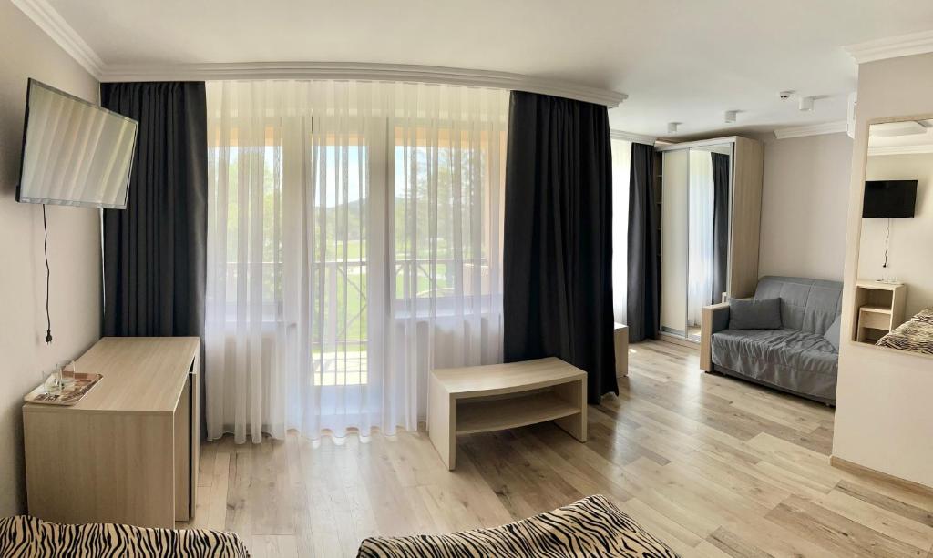 a living room with a large window and a couch at Hotel Intourist in Mukacheve