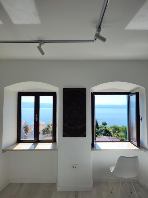 a white room with two windows and a chair at NEBOKRAJ in Kraj