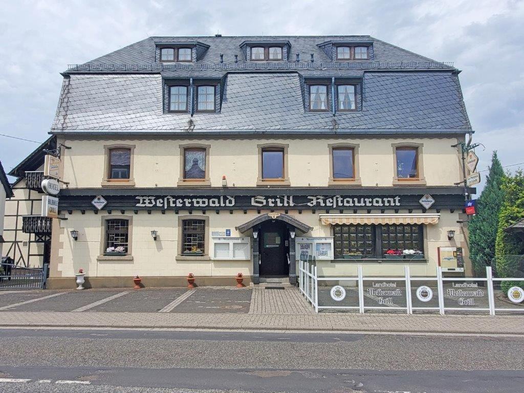 un grand bâtiment au coin d'une rue dans l'établissement Landhotel Westerwaldgrill, à Höhn