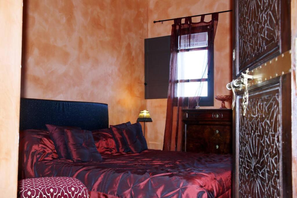 a bedroom with a red bed and a window at Chambre Meknes, Riad 7 au village naturiste Couple only in Cap d'Agde