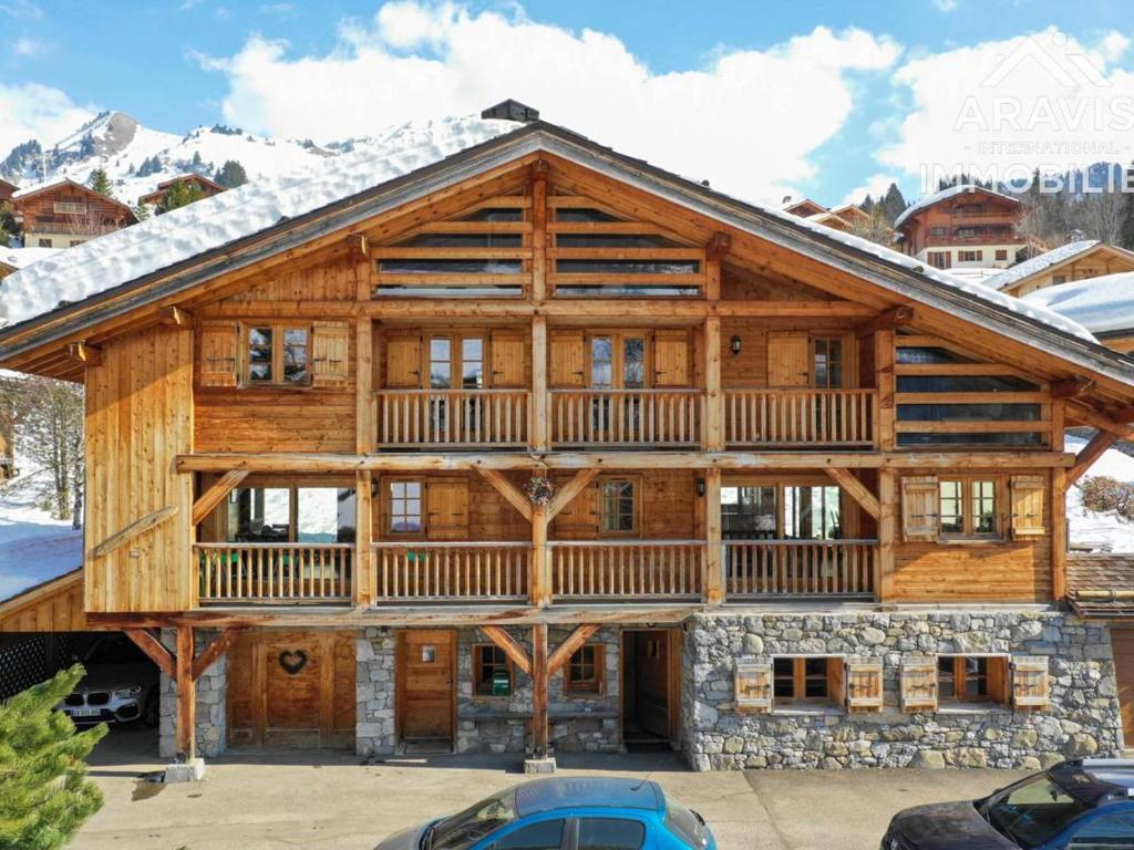 a log cabin with a wrap around porch and a wrap around deck at Chalet Le Grand-Bornand, 8 pièces, 11 personnes - FR-1-391-22 in Le Grand-Bornand