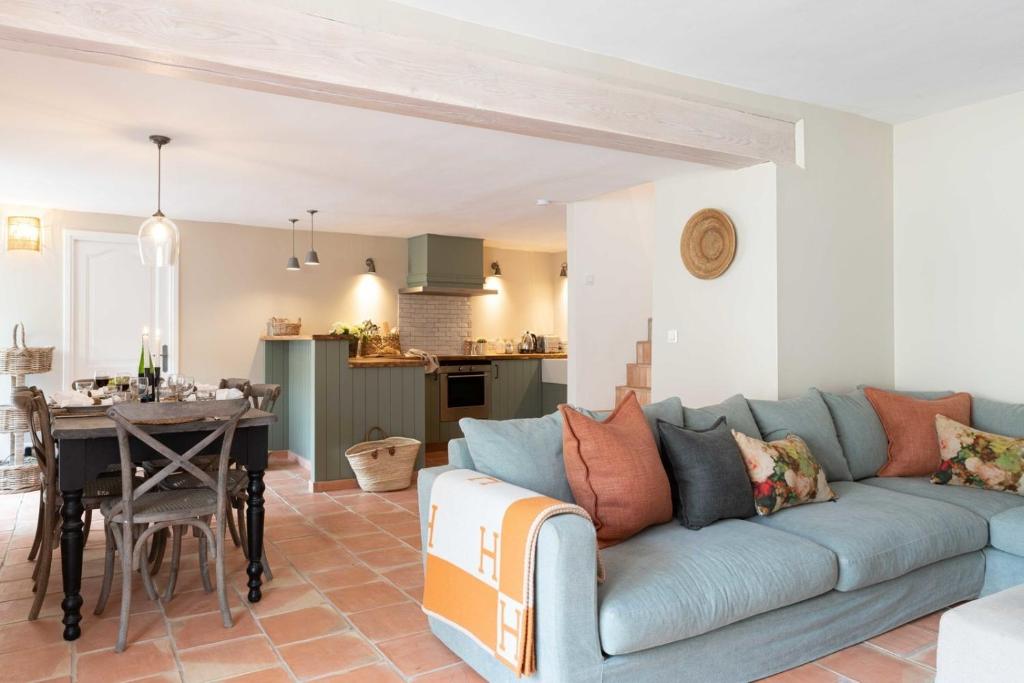 sala de estar con sofá azul y cocina en Pretty Historical Village House, en Grimaud