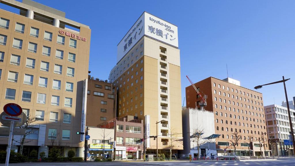 un edificio alto en una calle de la ciudad con edificios en Toyoko Inn Kanda Akihabara en Tokio