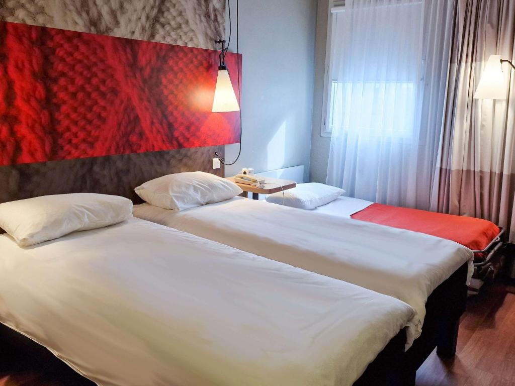 dwa łóżka siedzące obok siebie w pokoju hotelowym w obiekcie Hotel ibis Dijon Centre Clemenceau w mieście Dijon