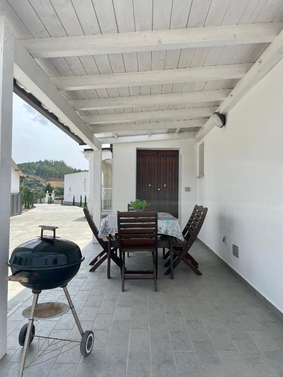 un patio con griglia, tavolo e sedie di Villa Claudia - appartamento A a Corazzello