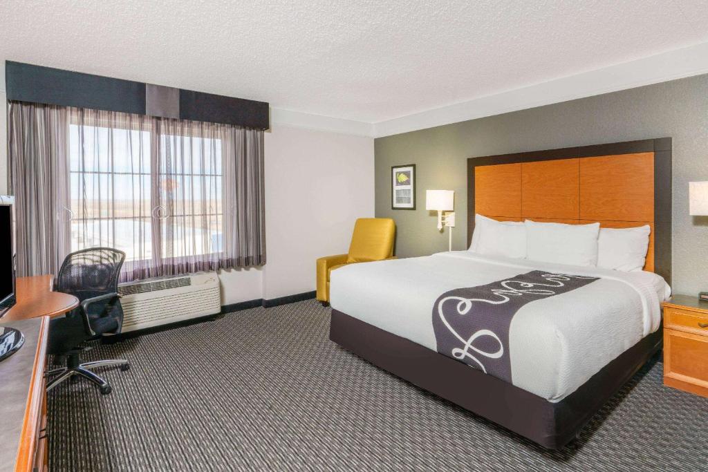 um quarto de hotel com uma cama grande e uma secretária em La Quinta by Wyndham Pueblo em Pueblo