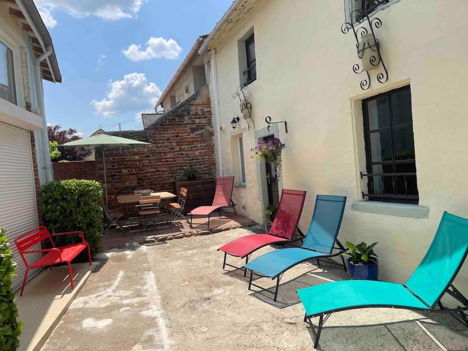 un groupe de chaises assis à l'extérieur d'un bâtiment dans l'établissement Maison au bord de l'Allier entièrement rénovée, à Joze