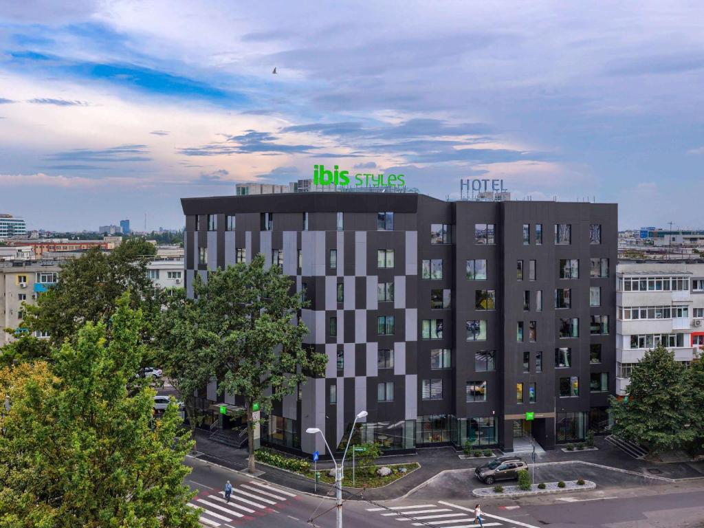 a building with a sign on the top of it at ibis Styles Bucharest Erbas in Bucharest