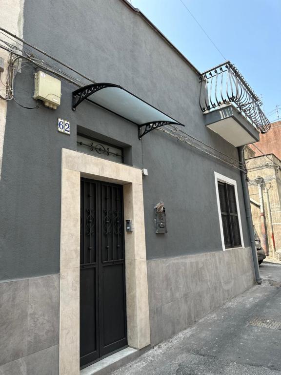 een gebouw met een zwarte deur en een balkon bij San Damiano Inn in Catania