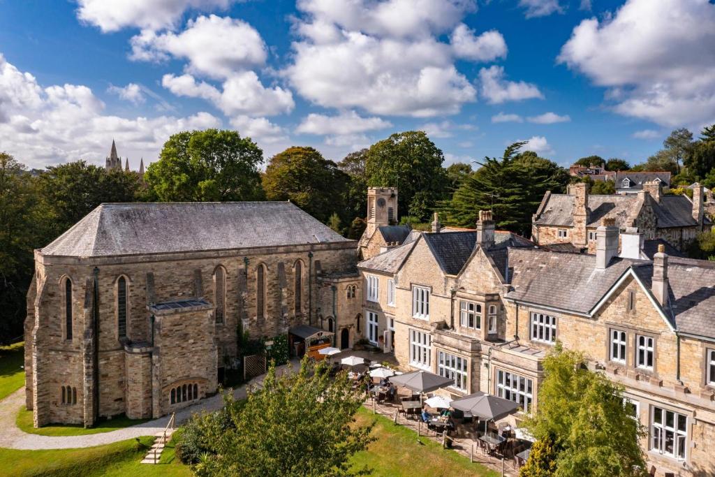 an aerial view of a large stone building with tables at The Alverton in Truro