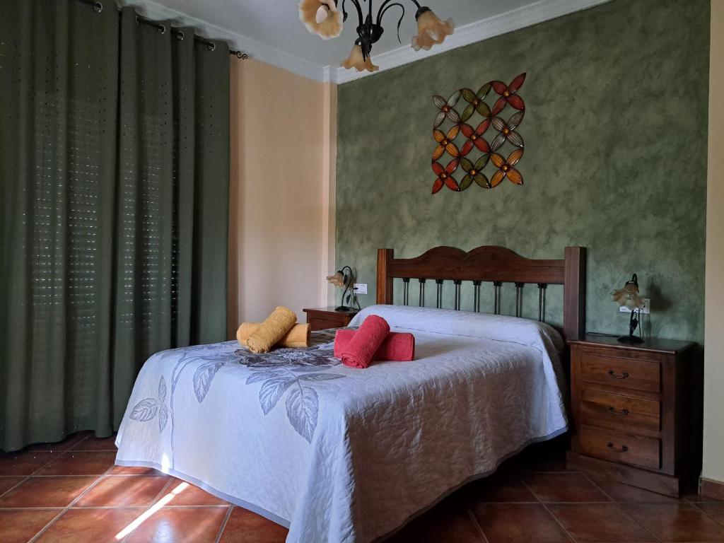 Un dormitorio con una cama con almohadas rojas. en Casa El Albero (Torcal-Caminito del Rey), en La Joya