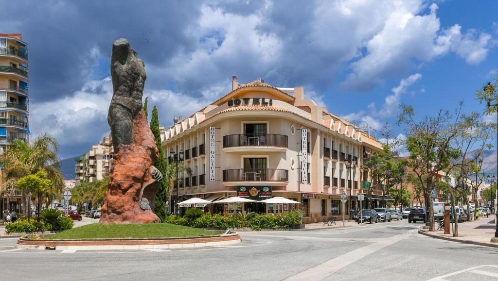 a building with a statue in the middle of a street at Hotel Galicia in Fuengirola