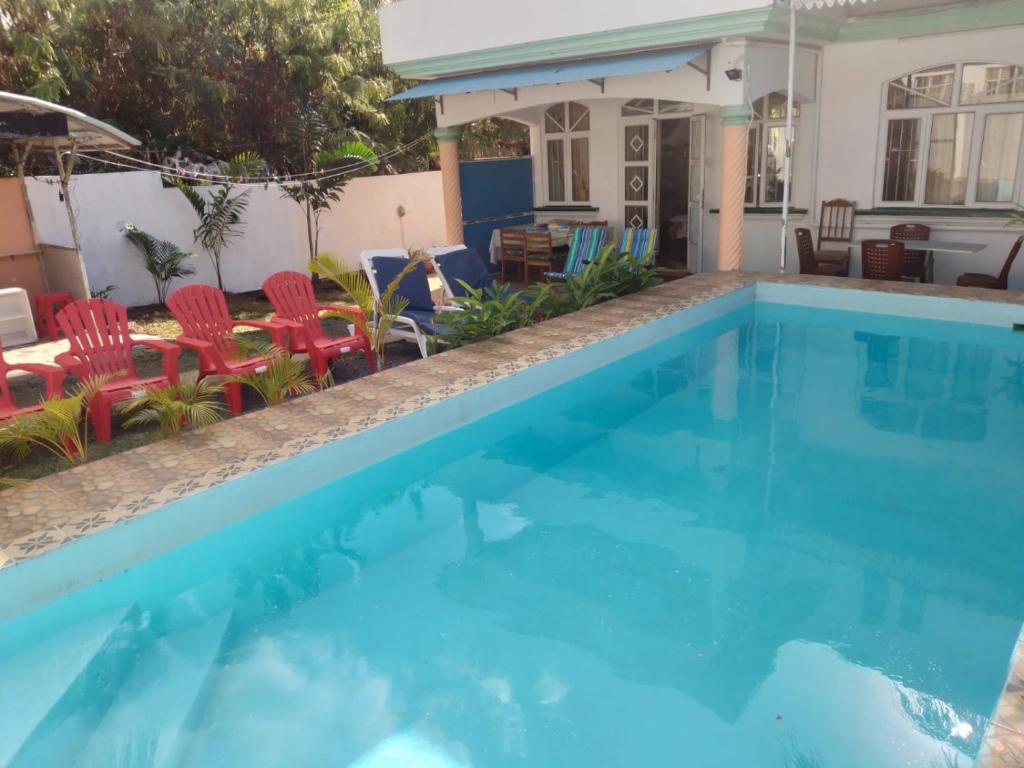 a swimming pool with chairs and a house at Villa GRAND BAIE LA CROISETTE in Grand-Baie