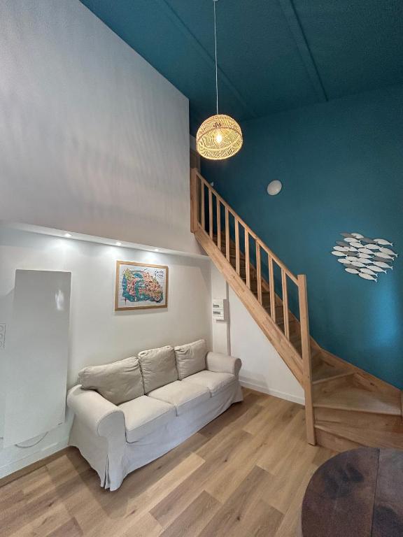 un salon avec un canapé et un escalier dans l'établissement Au domaine des sources, à Grosbreuil