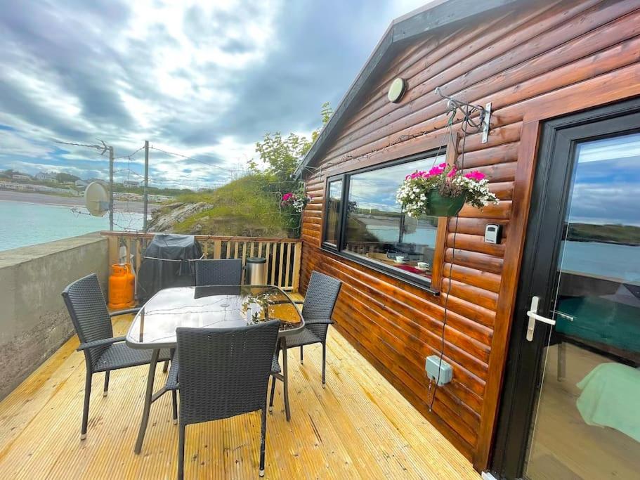 Cosy Portmor Log Cabin في Malin Head: طاولة وكراسي على سطح المنزل