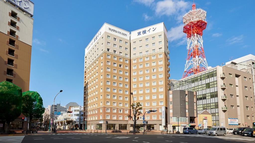 un edificio alto con una torre encima en Toyoko Inn Shonan Hiratsuka eki Kita guchi No 1 en Hiratsuka