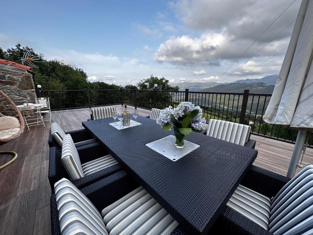 une table noire avec un vase de fleurs sur une terrasse dans l'établissement Arcadia, à Secadura