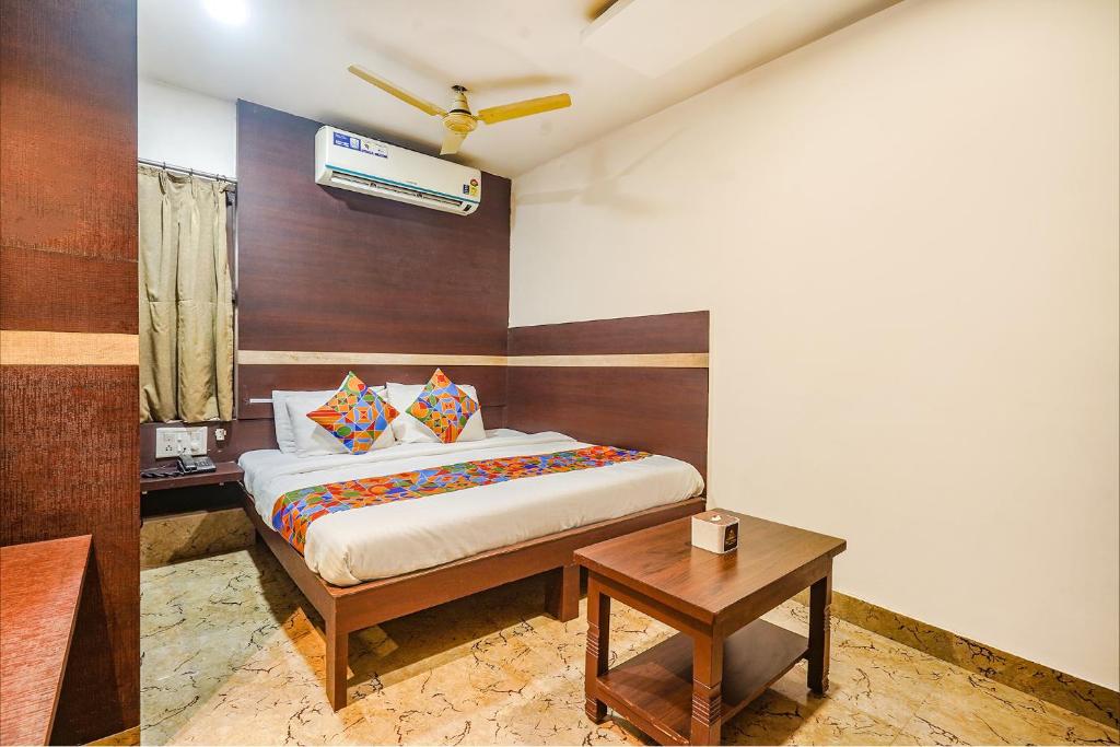 a bedroom with a bed and a table at FabHotel Shravan in Nagpur