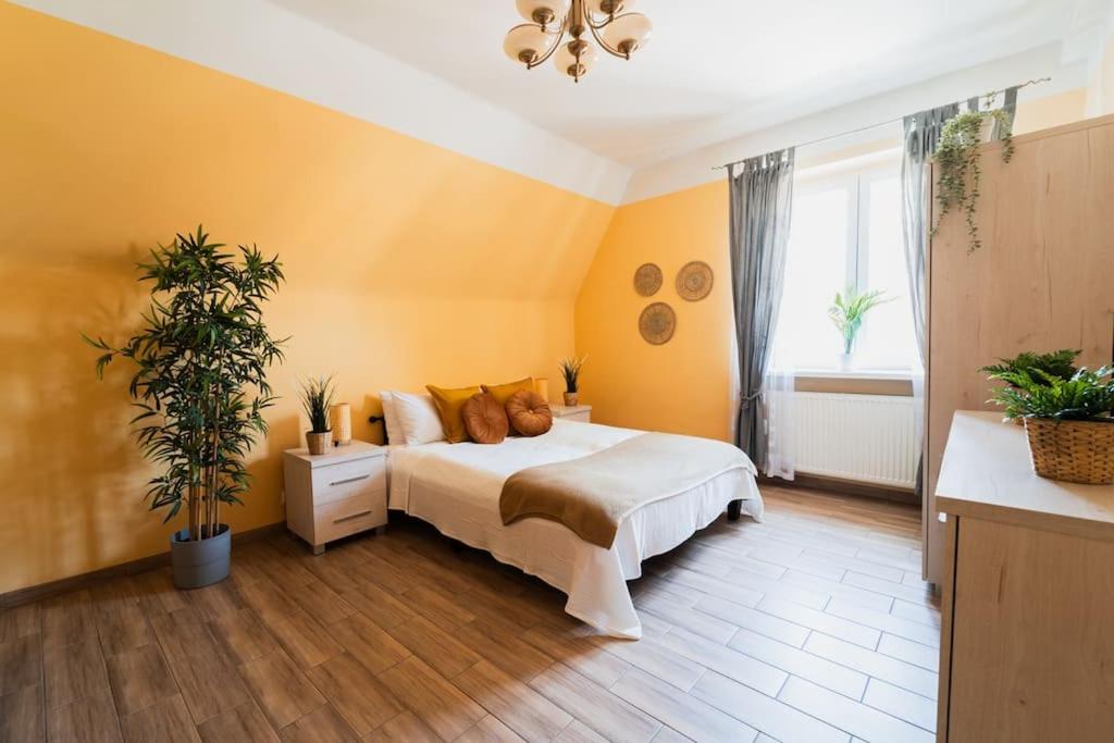 a bedroom with a bed with yellow walls at Market Square - street Rynek 24 -2 Rooms in Wrocław