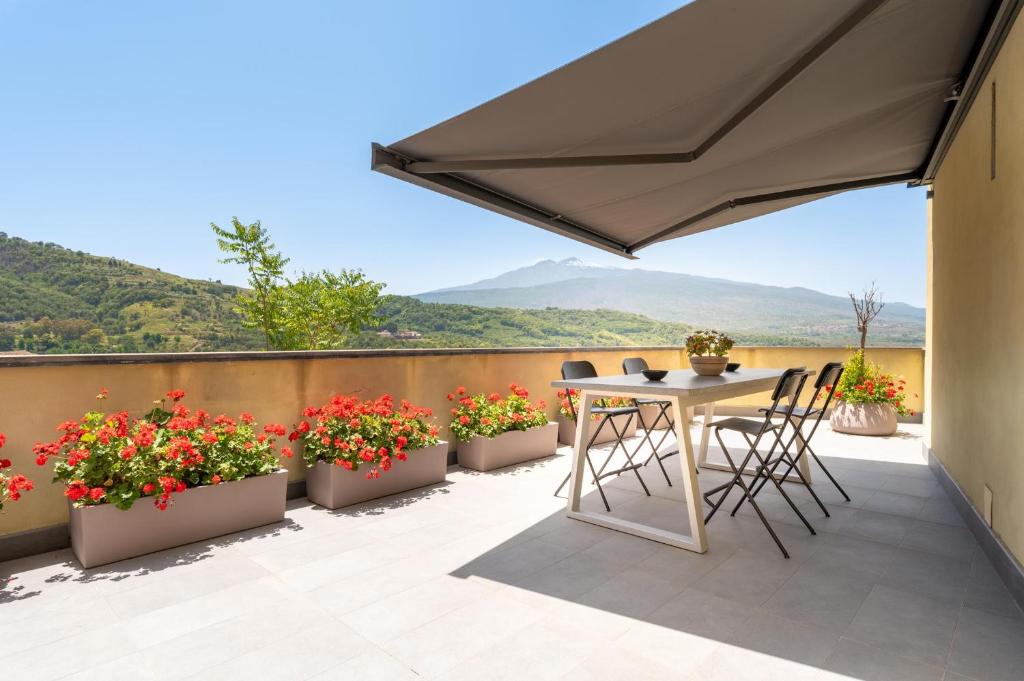a patio with flowers and a table and chairs at La Dimora del Castelluccio in Castiglione di Sicilia