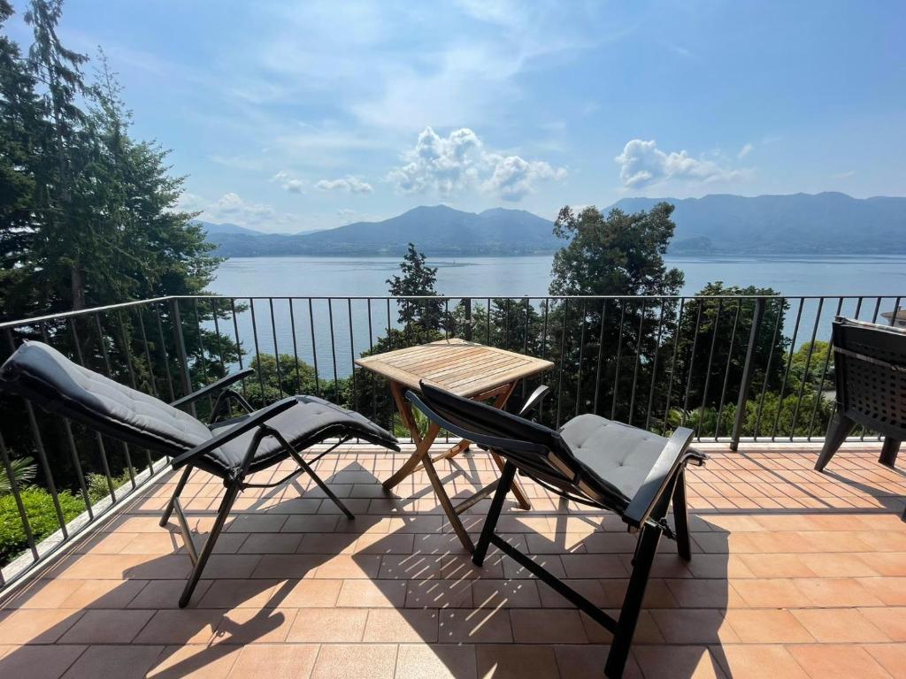 a table and chairs on a balcony with a view of the water at Gioia in Oggebbio