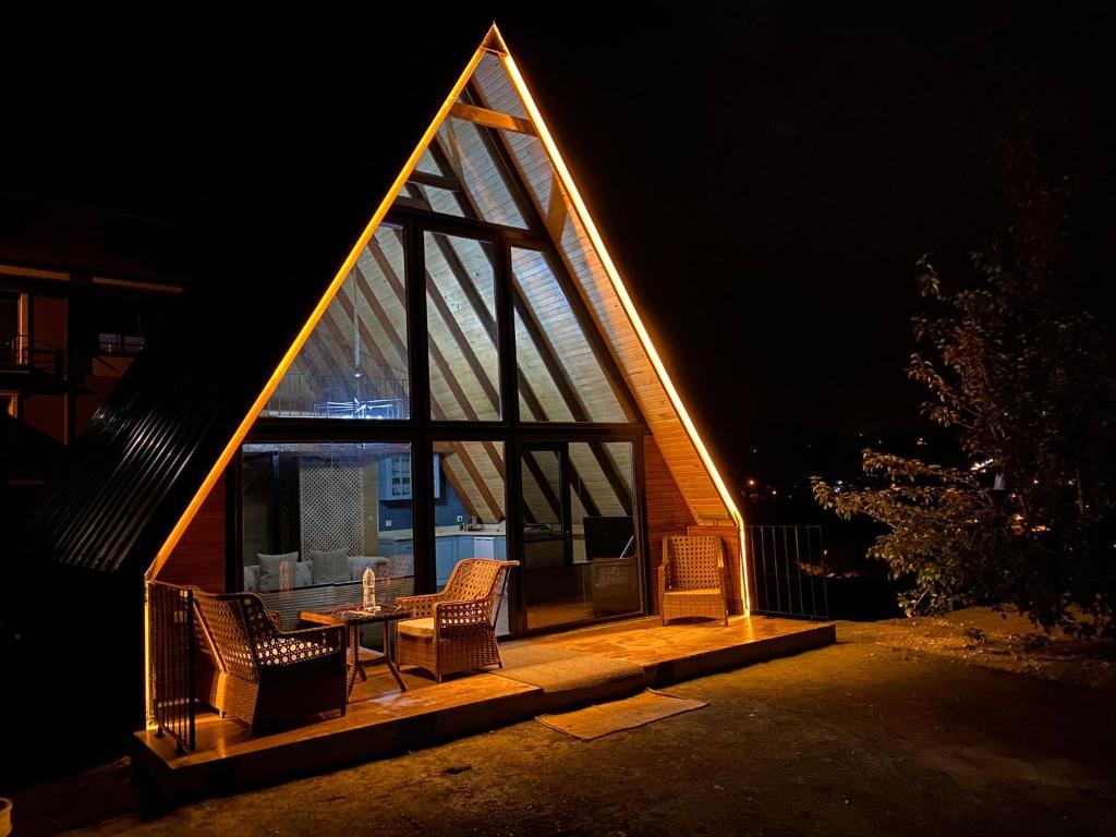 a house with a triangular roof with a table and chairs at Private Bungalow in Trabzon