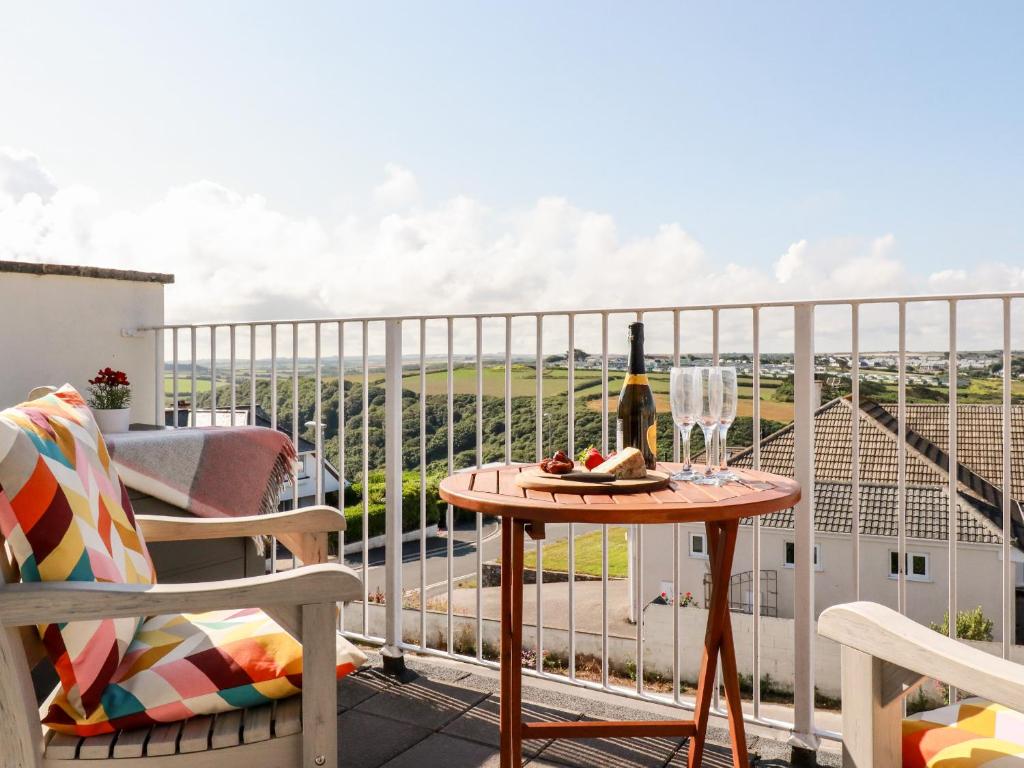 a balcony with a table and a bottle of wine at Far Horizons in Newquay